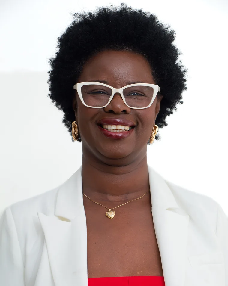 Rose Cipriano, retrato de estúdio, sorrindo de frente.